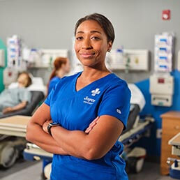 Joyce University nursing student in blue scrubs standing in simulation lab on campus