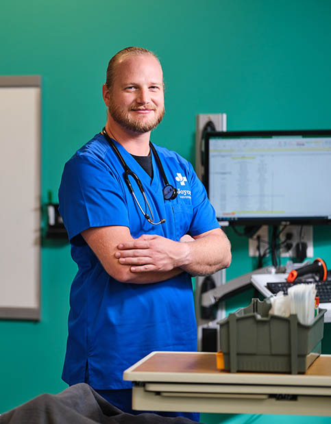 Nursing student in blue Joyce University scrubs standing in simulation center