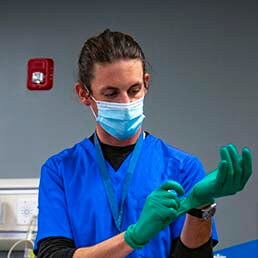 Joyce University student in blue scrubs and personal protective gear