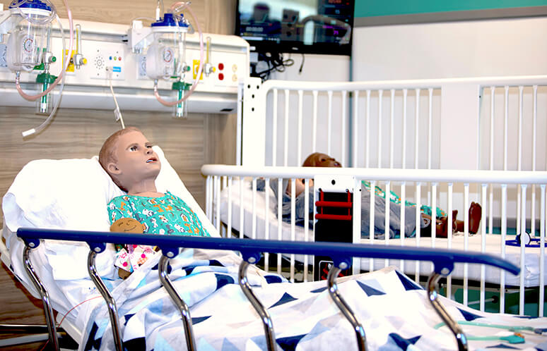 Pediatric high fidelity mannequin patient in hospital bed in Joyce Johnson simulation center