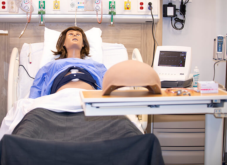 Obstetrics high fidelity mannequin in hospital bed in the Joyce Johnson simulation center on Utah campus