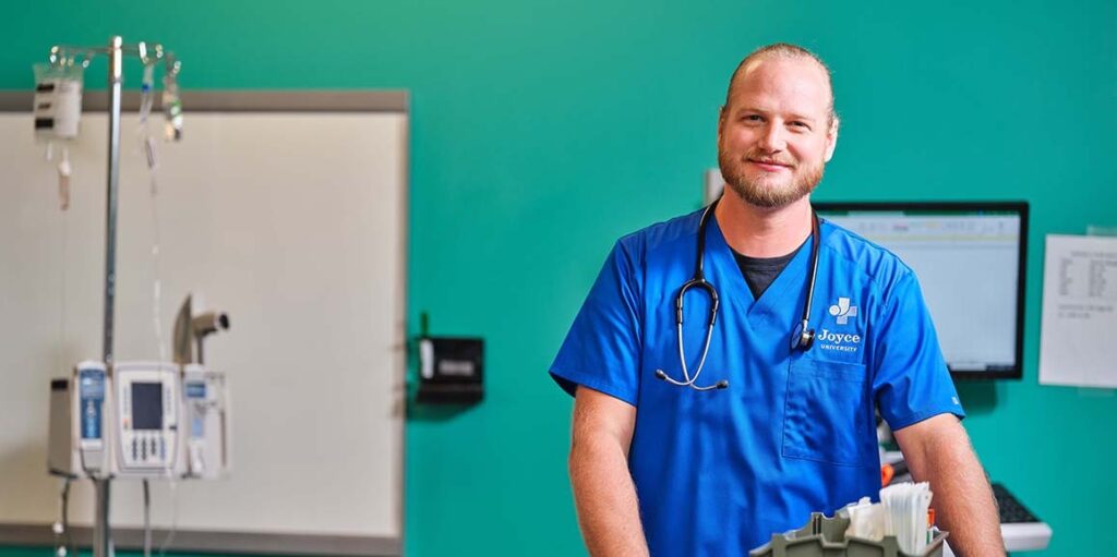 Joyce University Student in Blue Scrubs Standing in Simulation Lab