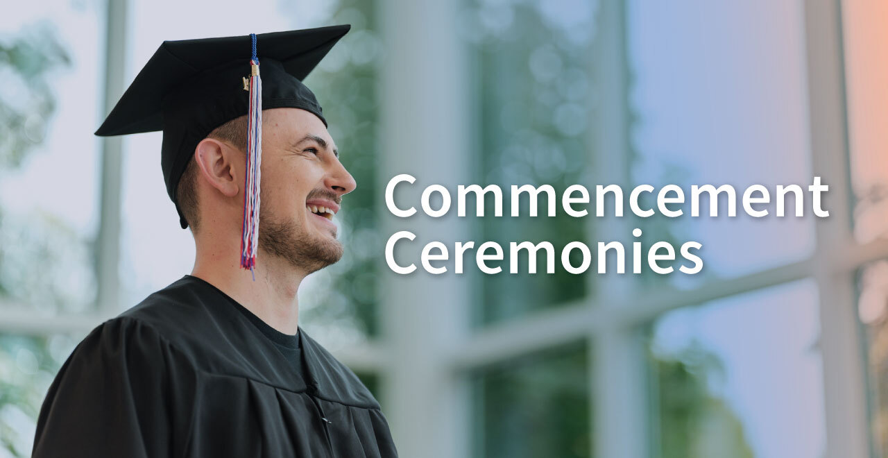Male student in cap and gown smiling away from the camera