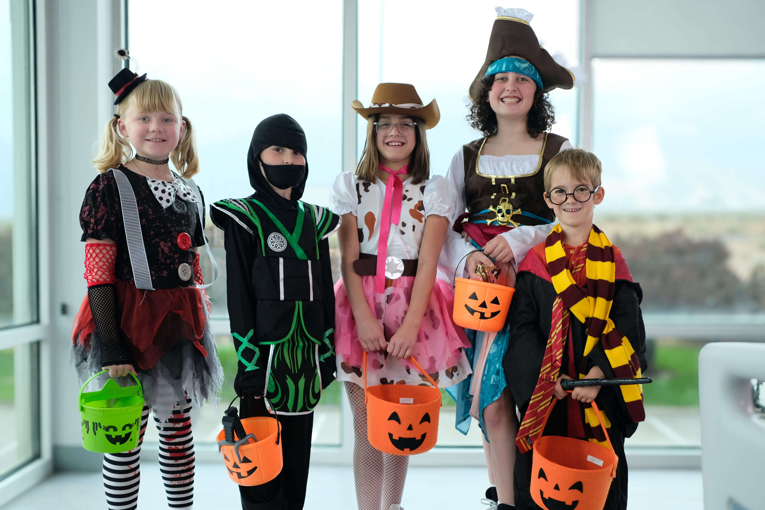 kids in halloween costumes holding trick or treat buckets