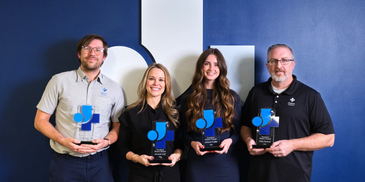 faculty, student, alumni, and staff holding standard bearer awards at Joyce University Standard Bearer Award Ceremony