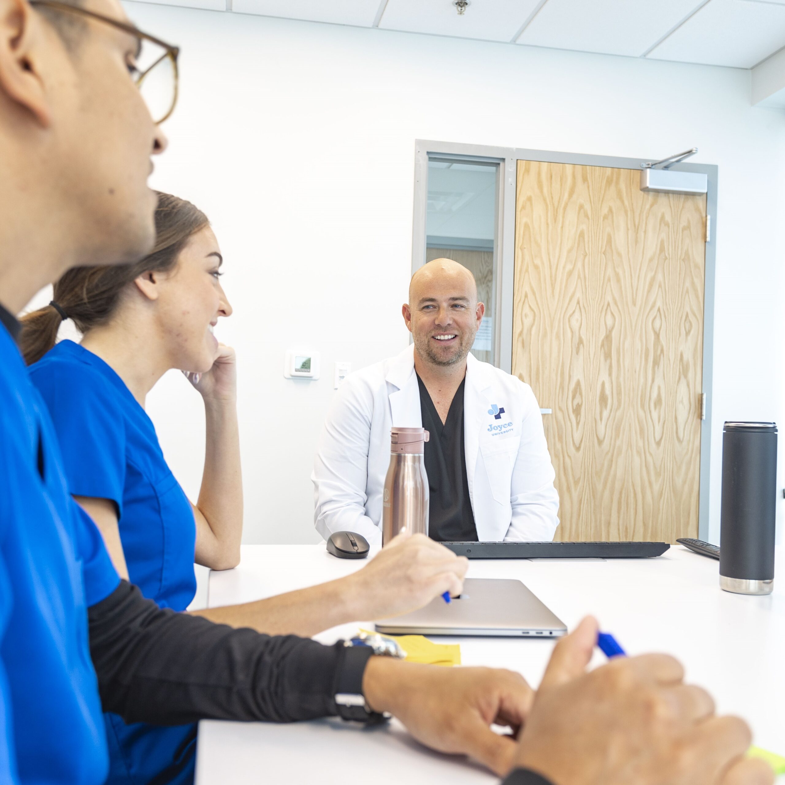 Joyce University Faculty in debrief room with nursing students