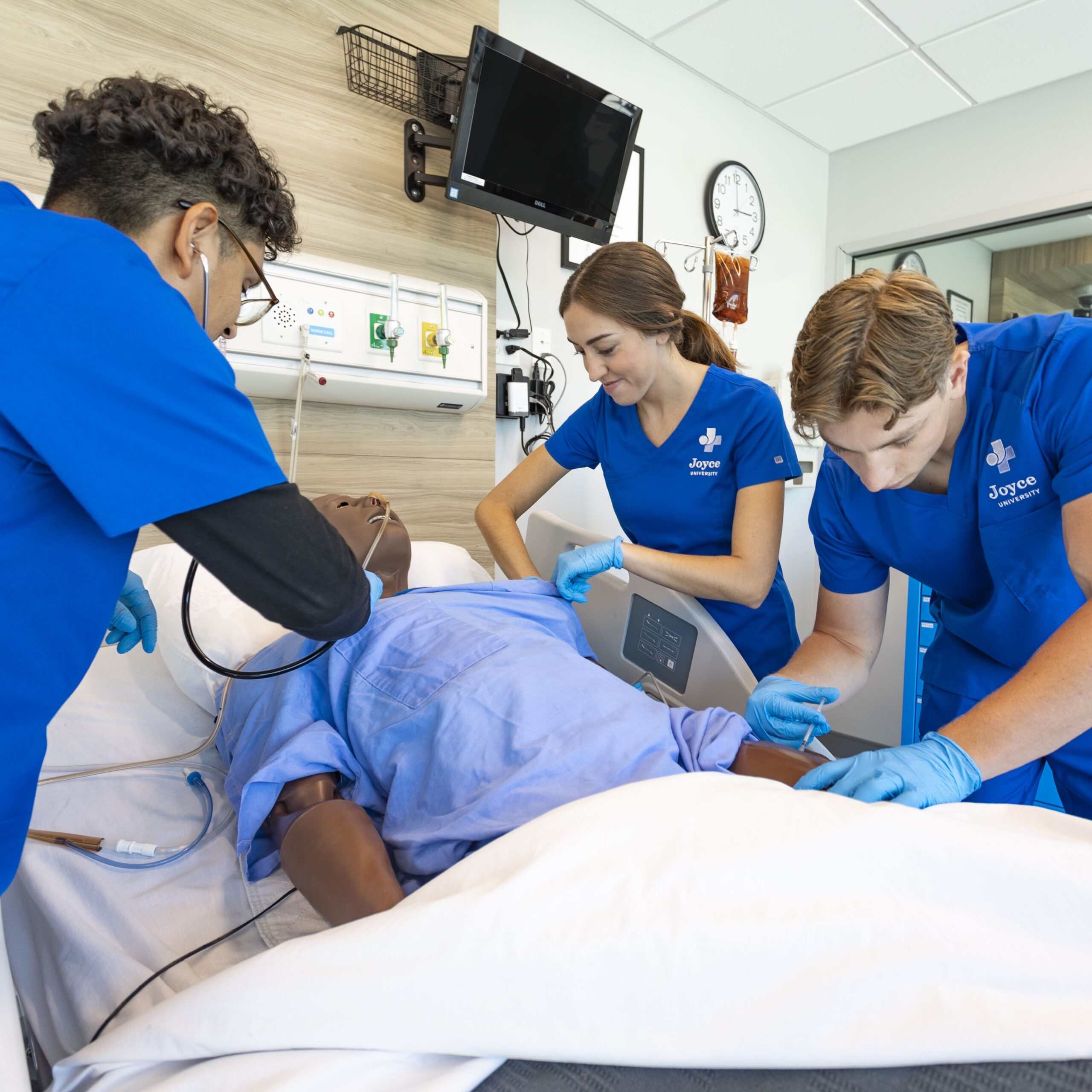 joyce university nursing students working on high-fidelity mannequin in simulation center