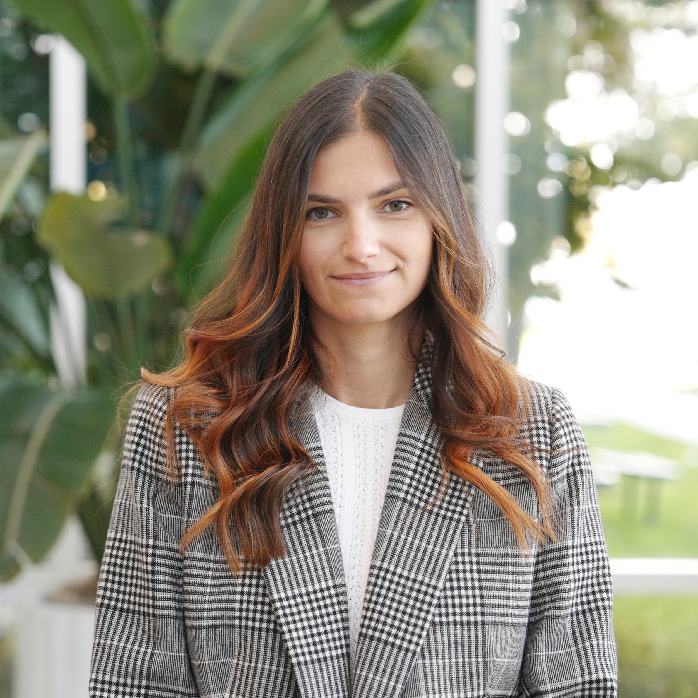 Kristina Duler Senior Director of Marketing standing in front of campus atrium