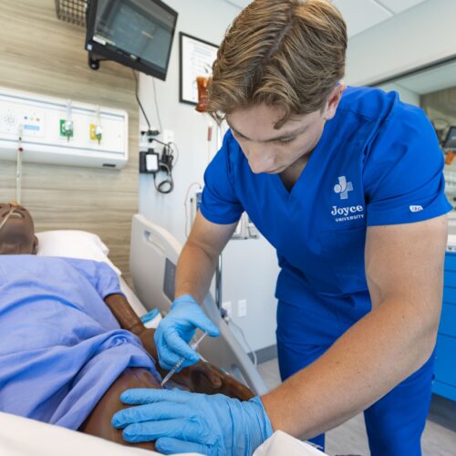 texas nursing student in joyce sim lab learning to give patient simulator an injection