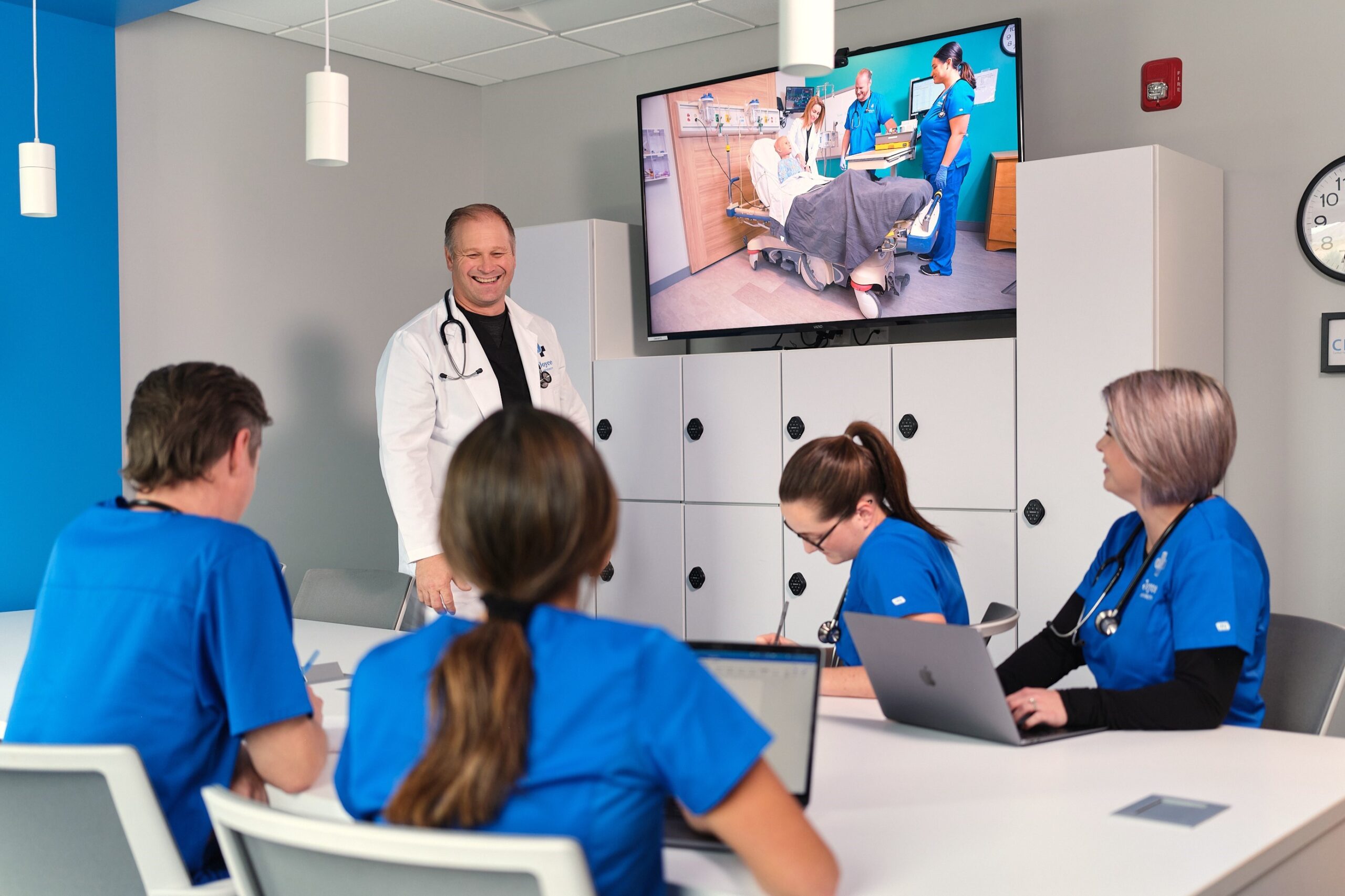 students and instructor in simulation debrief room