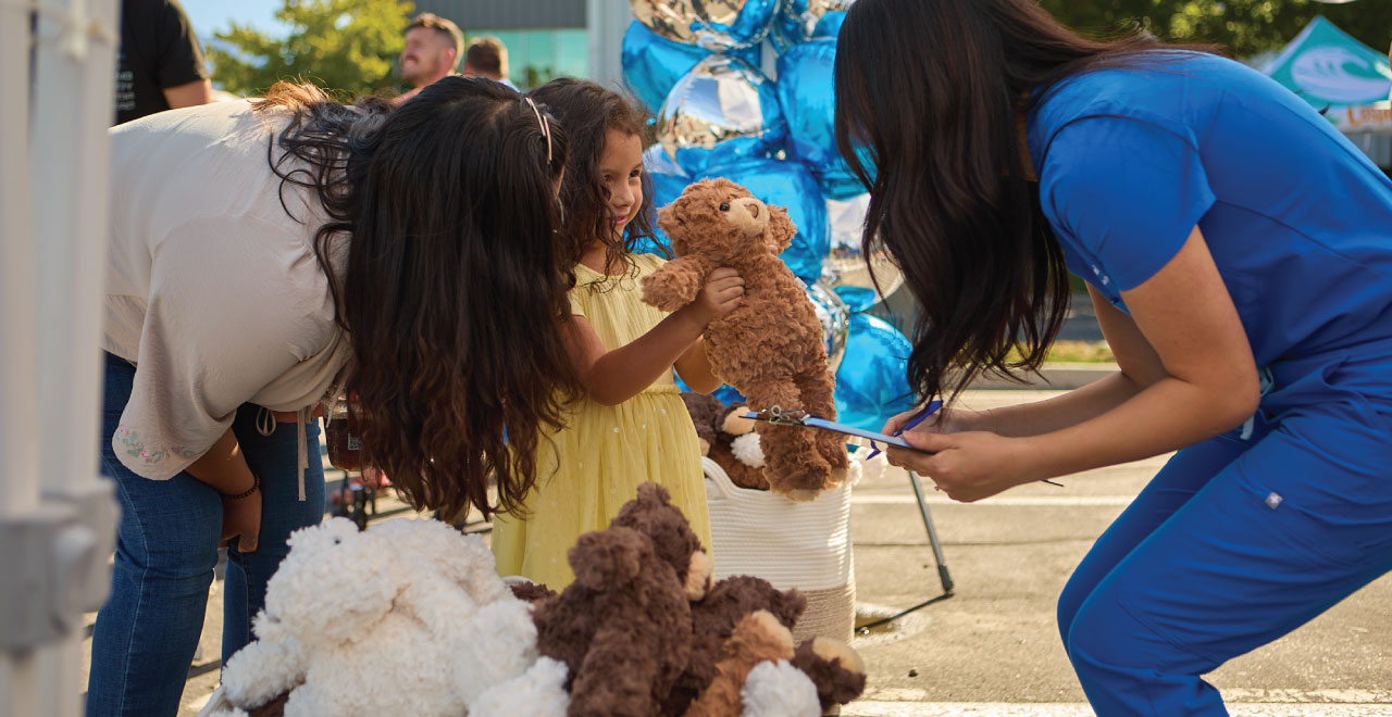 A child at the Joyce University Health Care and Teddy Bear Clinic getting a teddy bear.